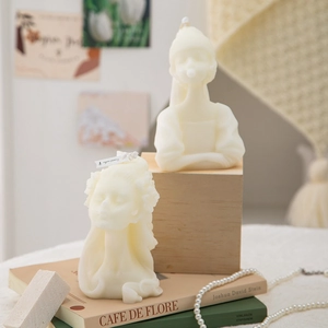 Artistic human portrait and pillar scented candles set on a book for home decor