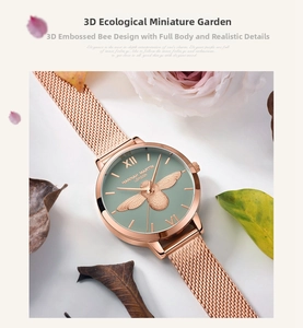 Détail d'une montre en maille or rose avec abeille 3D sur un cadran vert Morandi