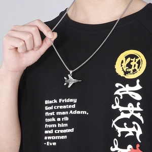 Close-up of a silver titanium steel fighter jet pendant necklace worn by a male model