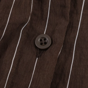 Gros plan sur tissu en popeline à rayures marron foncé avec un bouton assorti