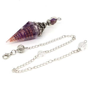 Detailansicht eines Amethyst-Pendels mit Kupferspirale und silbernem Kronendekor