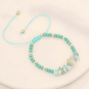 Handmade woven natural stone bracelet with blue beads and adjustable cord on white tray