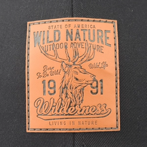Black trucker hat featuring a brown leather patch with a detailed embossed deer head