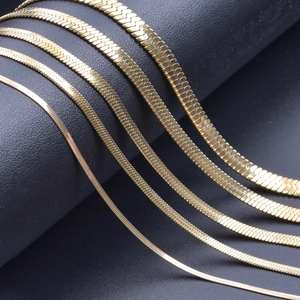 Flat snake chains in 18k gold plating shown in five varying widths on black display