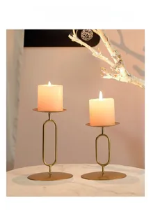 Matte gold minimalist metal candle holder set on marble surface with white candles