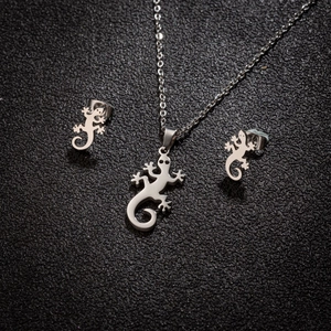 Set collana e orecchini a forma di geco lucido in acciaio su sfondo nero opaco