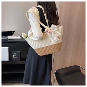 Detail of woven tote bag featuring white lace bow and delicate pink floral embroidery