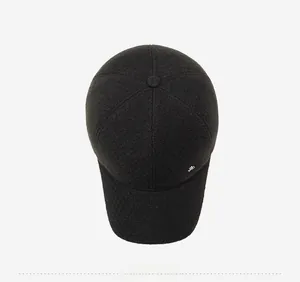Top down view of black wool baseball cap with side silver metal accent and thick fabric