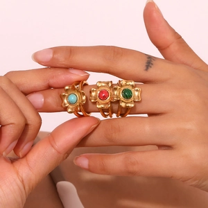 Three vintage 18K gold plated clover rings with turquoise, red, and green stones