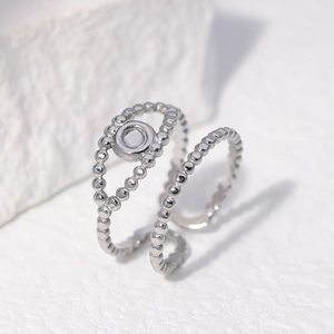 Détail de la bague double couche argentée perlée avec cercle plat sur décor blanc