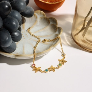 18K gold plated starfish bracelet with colorful zircon stones on a shell-textured tray