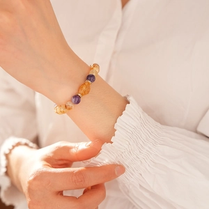 Close-up of Citrine and Amethyst beaded bracelet with golden accents on model's wrist