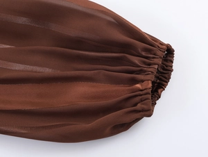 Détail de la manche d'une robe ethnique marron rayée avec poignet élastique et fil métallique