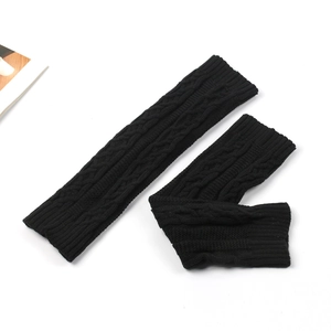 Close-up of black cable knit leg warmers showing detailed texture and soft thick yarn