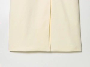 Detail of off-white wool jacket hem showcasing premium texture and precise stitching