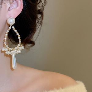 Close-up of elegant French vintage teardrop pearl fringe earrings on a model ear