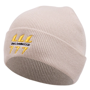 Détail du bonnet en maille beige avec broderie Swag Shininggod et le logo 777