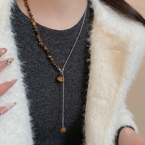 Model wearing a tiger eye beaded Y-necklace with silver chain and gemstone pendant
