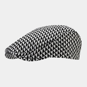 Detail view of British retro flat cap with black and white geometric triangle pattern