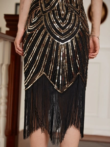 Détails des motifs de paillettes en V et des longues franges noires sur la robe de soirée