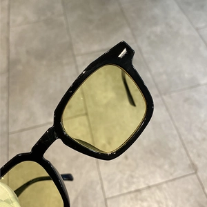 Retro square sunglasses with thick black frames and translucent yellow lenses for women