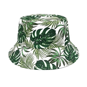 Detailed view of tropical green leaf print and fine stitching on white cotton bucket hat