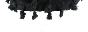 Macro detail of black satin-lined beanie featuring decorative fringe on the edge