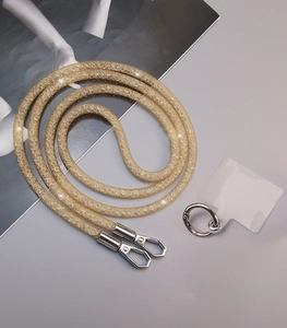 Detail of a sparkling gold mesh phone lanyard with metal clasps and connection tab