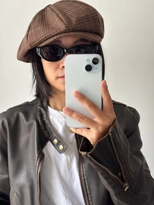 Detail of dark brown checkered newsboy cap with vintage texture and retro British style