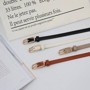 Collection of four slim leather belts in black, white, khaki, and brown with gold buckles
