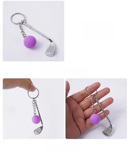 Macro detail of silver golf club keychain with textured purple ball and metallic ring