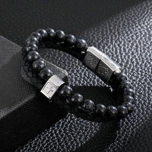Detail of men's double-layer black beaded leather bracelet with cross metal clasp