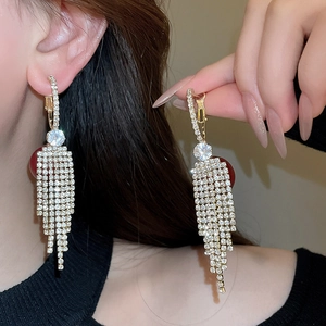 Detail of long fringe drop earrings with sparkling rhinestones and silver needle