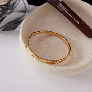 Minimalist 18K gold stainless steel hammered bangle with round crystals in a chic display