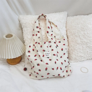 Détail du sac cabas en velours côtelé aux motifs fraises et étiquette tissée