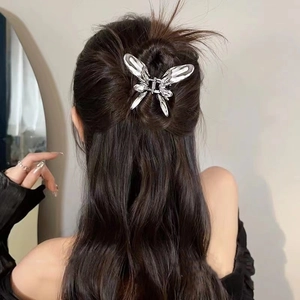 Silver butterfly hair claw clip with diamonds on long wavy hair from back view