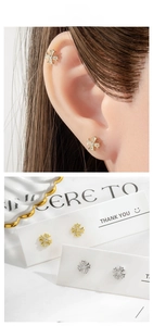 Close-up of gold and silver cross stud earrings with sparkling pave zircon stones