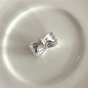 Elegant 925 sterling silver bow knot ring displayed on a minimalist white ceramic tray