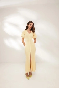 Detail of light yellow knit midi dress with V-neck, buttons and side slit texture