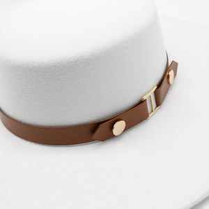 Close-up of white wool felt fedora featuring a brown leather band and golden H buckle