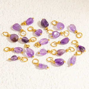 Macro shot of irregular translucent purple stone pendants with gold metal ring for DIY jewelry