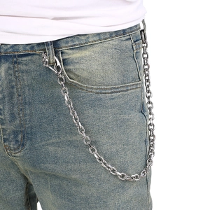 Detail of silver metal punk wallet chain hanging on blue denim jeans belt loop