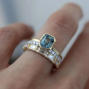 Ensemble de trois bagues en or 18K avec pierre bleue taille émeraude sur mannequin
