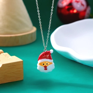 Nahaufnahme der Weihnachtsmann-Halskette mit glitzerndem rotem Hut und Harzanhänger