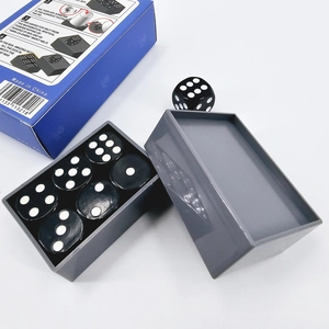 Close-up of dice miracle magic trick set with six black dice and gray storage box