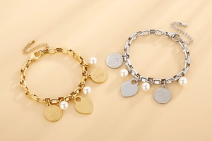 Détails de breloques cœur dorées et argentées avec perles sur bracelets à maillons
