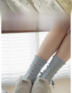 Détail de chaussettes bleues à pois avec bordure élastique large et finitions volantées