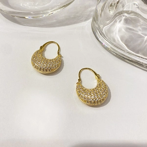 Macro shot of gold-plated U-shaped earrings with micro-pave cubic zirconia inlay