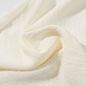 Macro detail of high-quality white lace fabric with elegant pleated texture and soft drape
