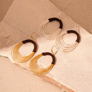 Exaggerated multilayer circle earrings with fabric-wrapped detail in gold and silver finish